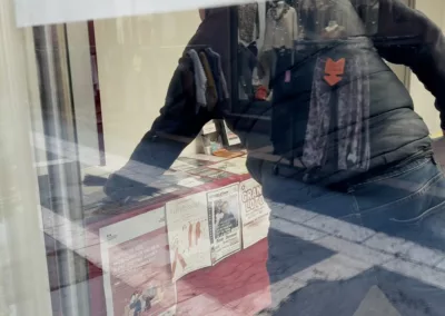 Un homme disposant des magazines Apt dans une vitrine d'un point de distribution.