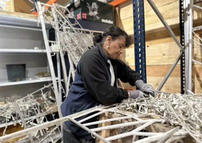 Blachère et Zou Vaï - Une femme concentrée sur le démantèlement d’un décor lumineux dans un atelier.