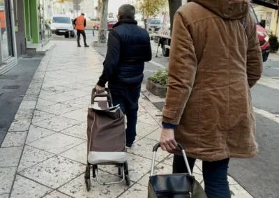 Deux personnes transportant des caddies remplis de magazines dans le centre-ville.