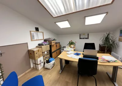 Nouveaux bureaux opérationnels - vue plus large dun bureau sous mezzanine avec des rangements des cartons et un espace de travail organise sous une lumiere naturelle